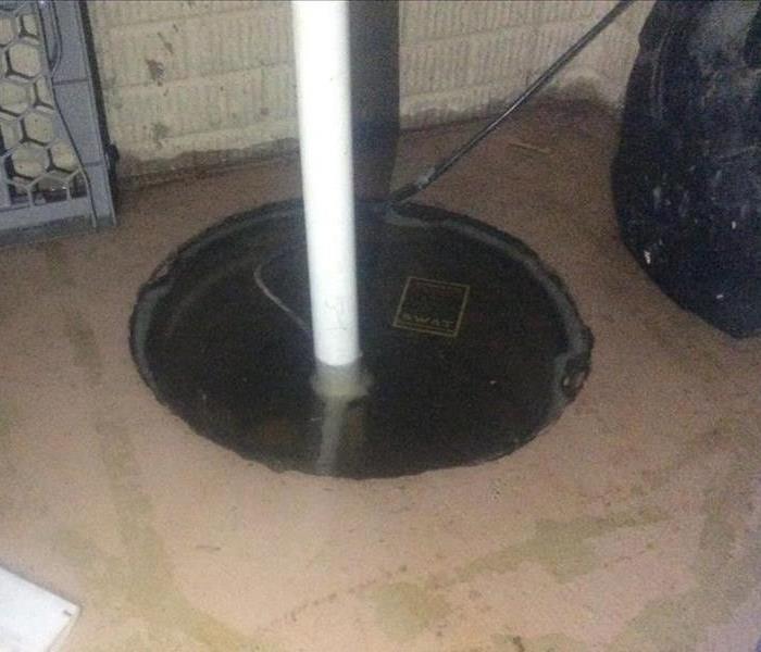 2   Wet concrete floor with sump pump filled to the top with water