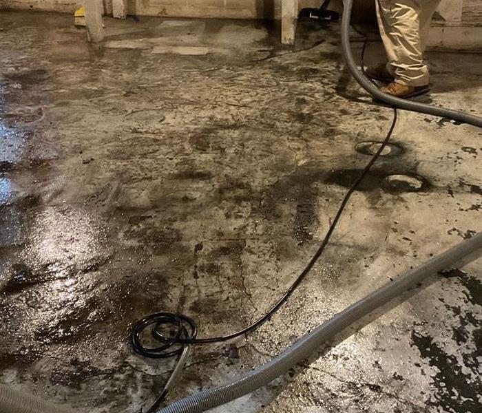 Wet Concrete floor with black dirt and sludge on it